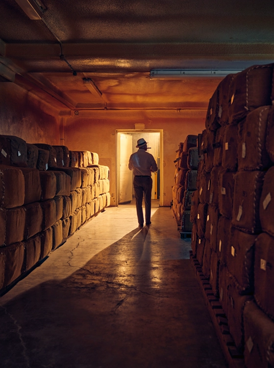A man standing in a room full of sacks.